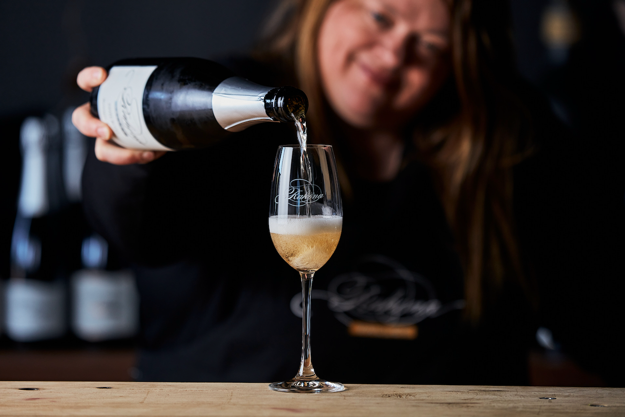 A woman pouring wine into a wineglass 